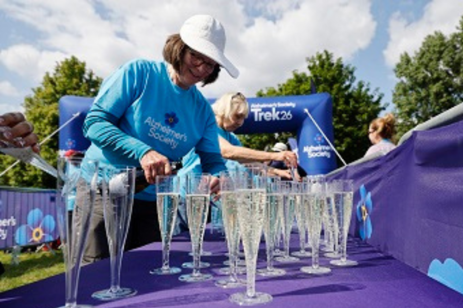 Volunteer pouring glasses of bubbly at finish line