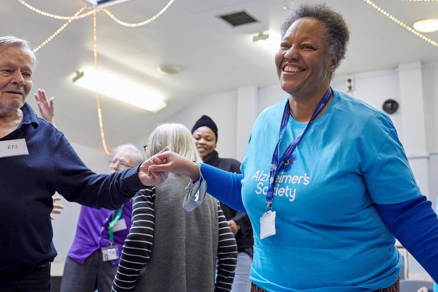 A woman in an Alzheimer's Society top dancing with a man with dementia