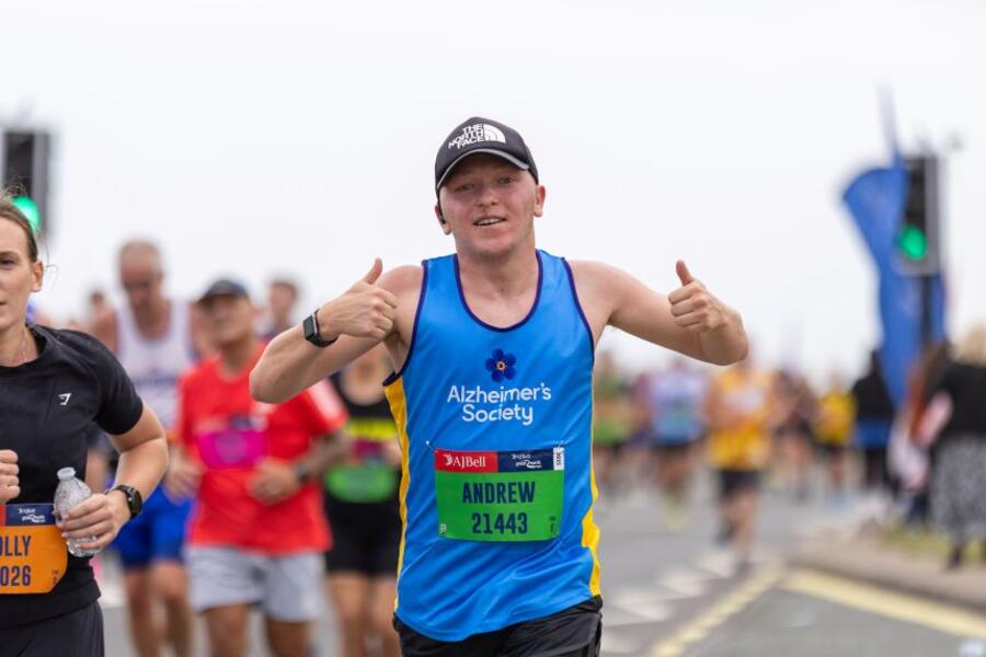 A man in an Alzheimer's Society top with two thumbs raised