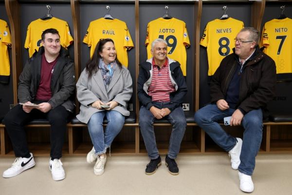 Four people sat smiling in the Wolverhampton Wanderers dressing room
