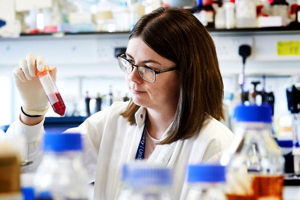 A female research looking at a tube of liquid