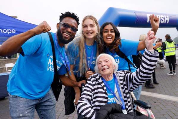 Group of 4 people smiling in front of the Memory Walk finish line. 