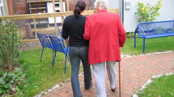 Care home staff walking with resident
