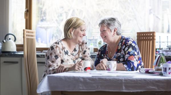 Two women sitting at a table laughing