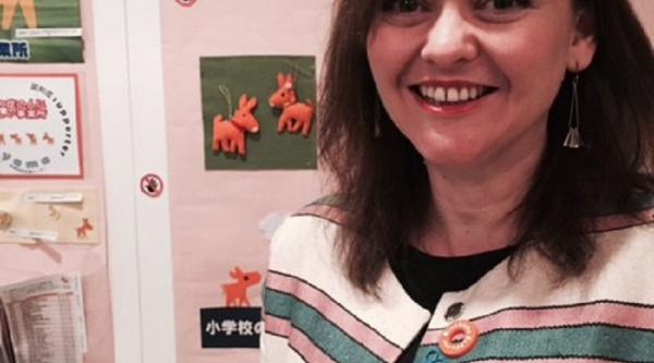 Woman standing in front of wall with art hung up on it