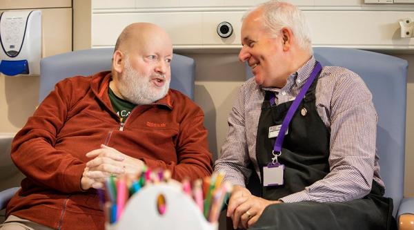A volunteer chats with a group member at Northern Ireland Hospice's Dementia Wellbeing Clinic