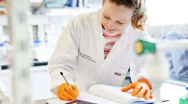 Researcher making notes in the lab