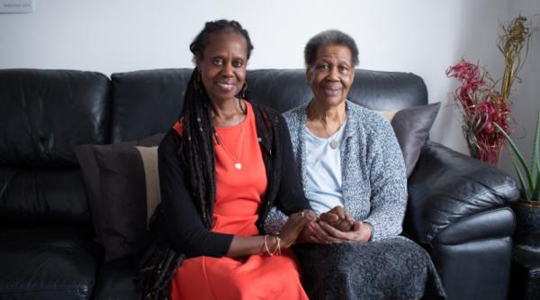 Enomwoyi and Pearl, sitting on the sofa and smiling