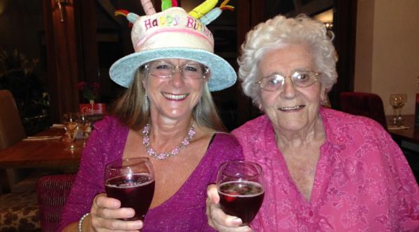 Jane and her mum smiling with wine glasses