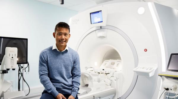 Dr Elijah Mak with an MRI scanner