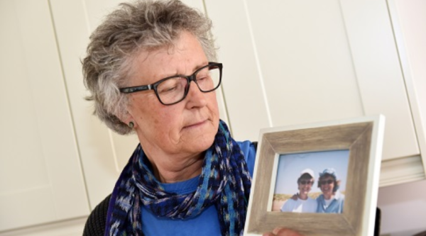 Rachael Dixey holding a framed photograph of her with her late partner, Irene Heron