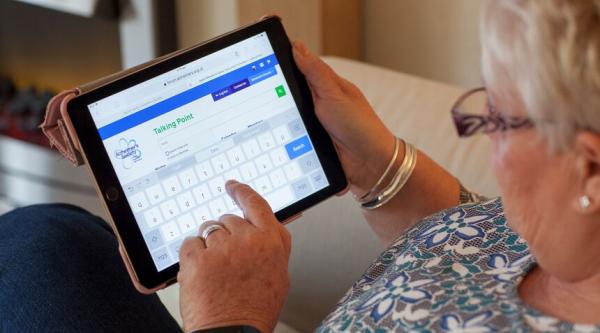 A woman uses Talking Point on a tablet device