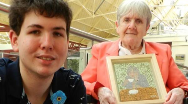 James with his grandmother Joan who holds up her artwork