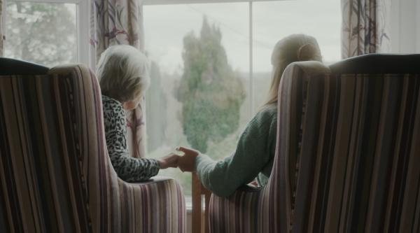 Saskia and Teresa holding hands in the care home