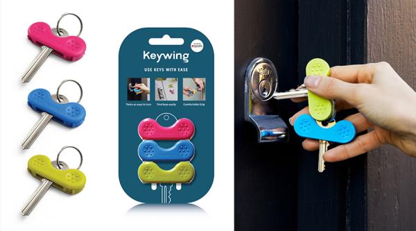 Keywings in their packaging and in use by a person's hand unlocking a door