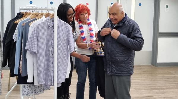 Customers at Hayes Cafe in west London, try on easywear clothes