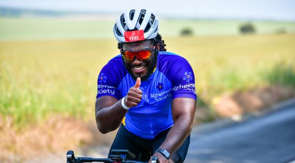 Man on bike smiling with thumbs up
