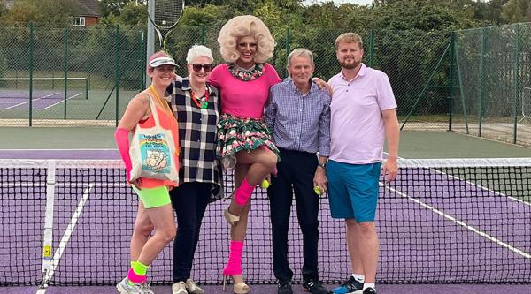 Craig Whymark on the tennis court in drag as Fanny Galore (centre) with his family and father Trevor to his left