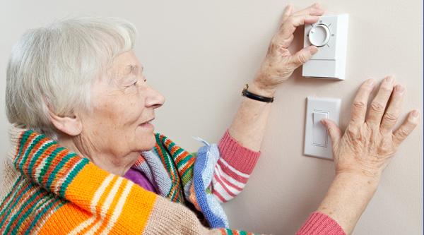 Person adjusting a thermostat