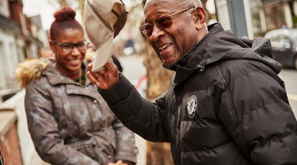 Person smiling and taking his hat off