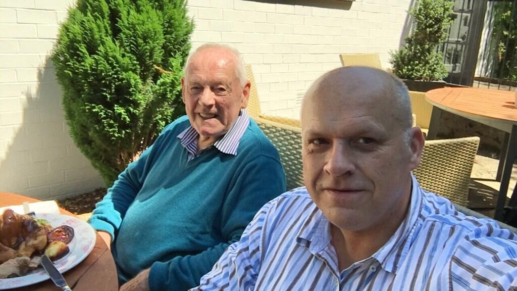 Andy and his dad enjoying food in the sunshine