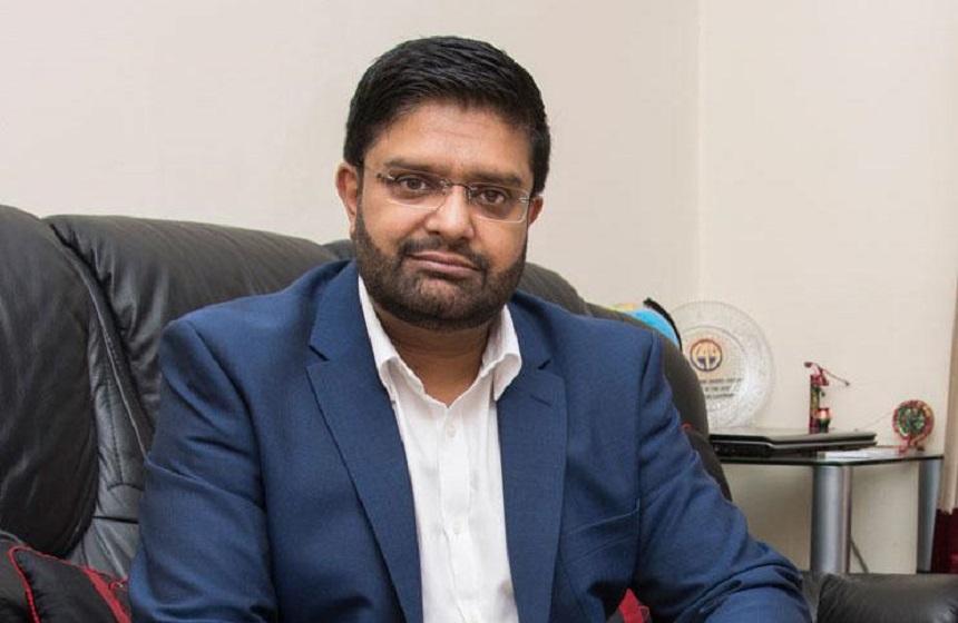 Carer Shahid Mohammed sitting on a sofa