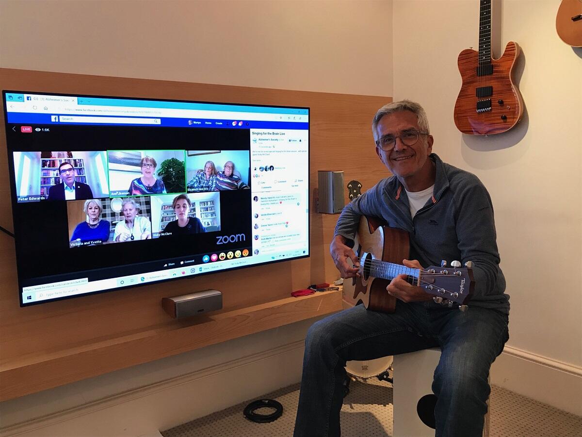 Martyn plays guitar along to Singing for the Brain Live