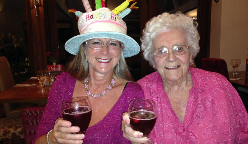 Jane and her mum smiling with wine glasses