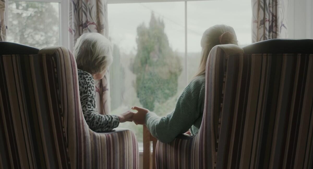 Saskia and Teresa holding hands in the care home