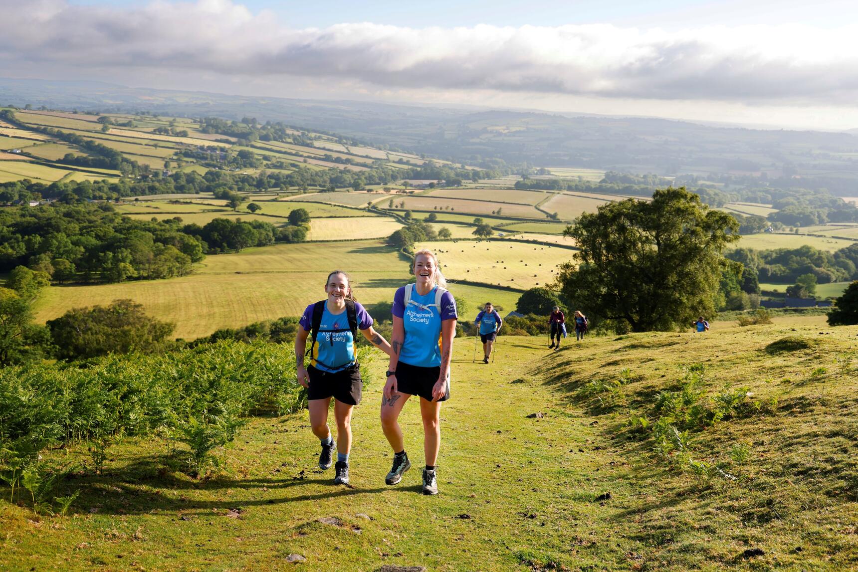 two people trekking though a field