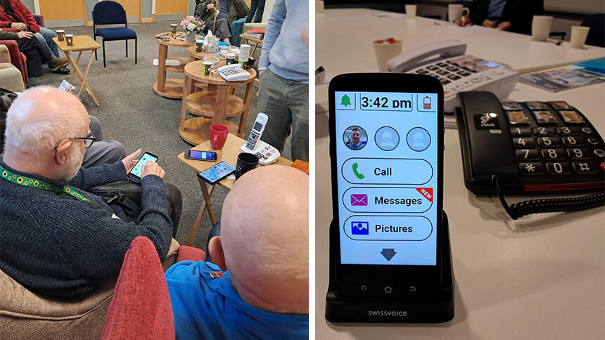 Two men sat in chairs looking at mobile phones and three phones on a table, a mobile and two landlines