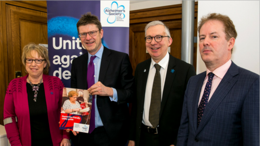 Four representatives in front of a 'united against dementia' banner