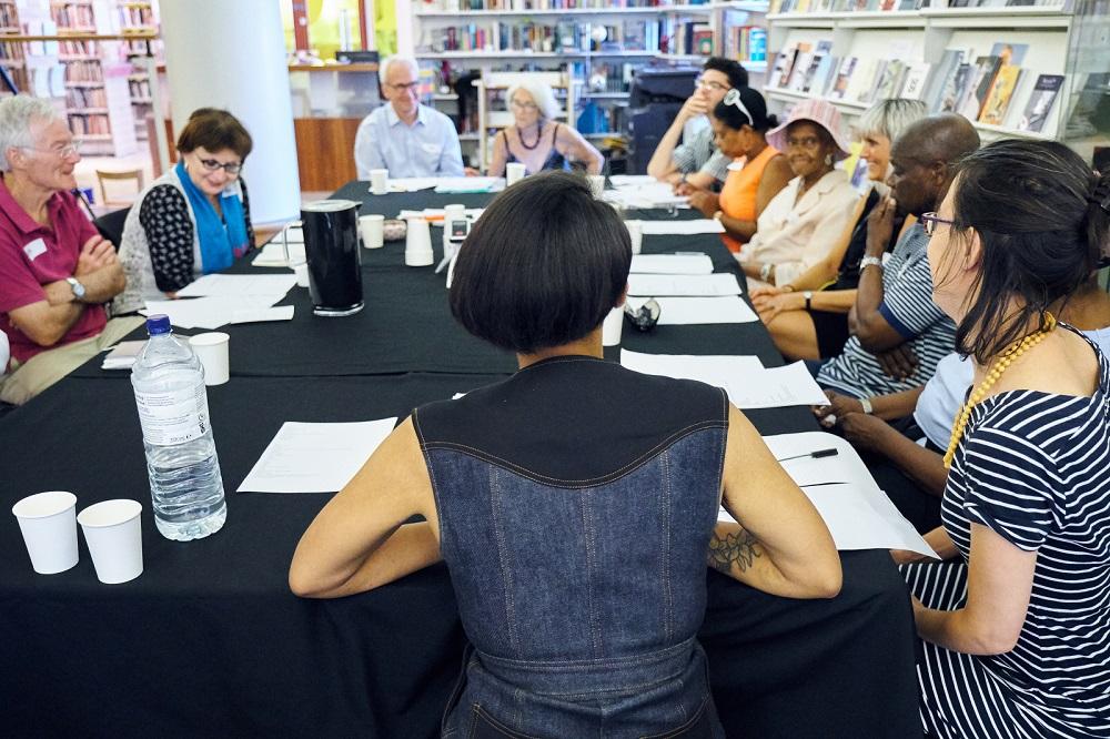 A group of people sat around a large table for the poetry workshop