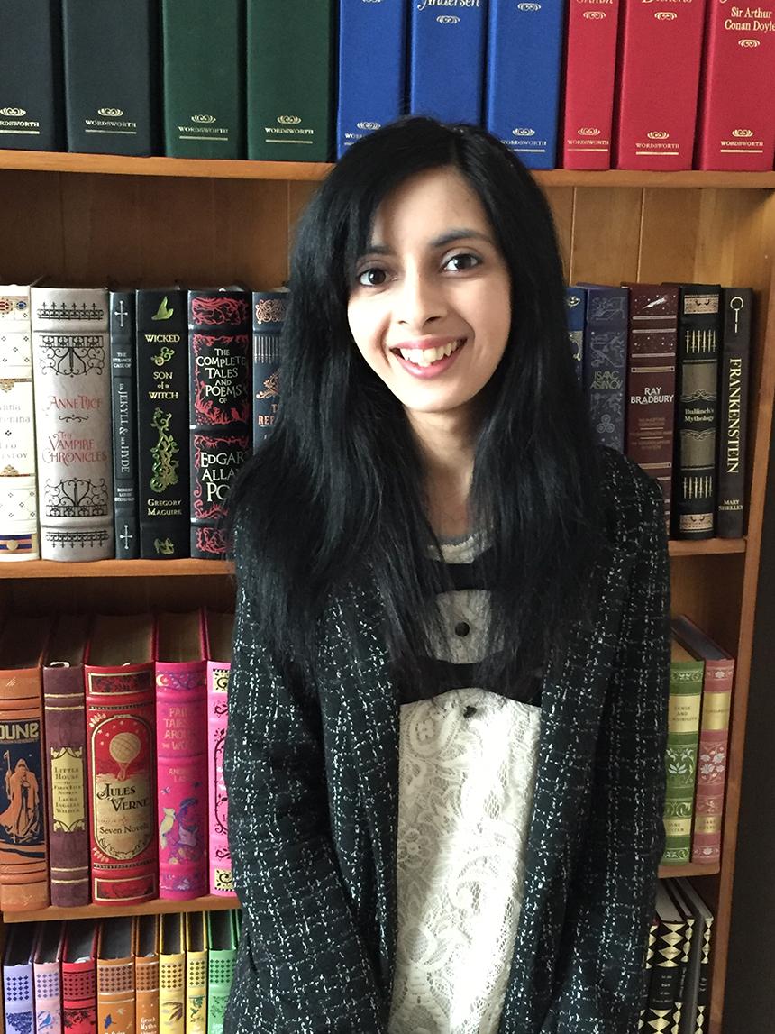 Sahdia Parveen standing in front of a book shelf