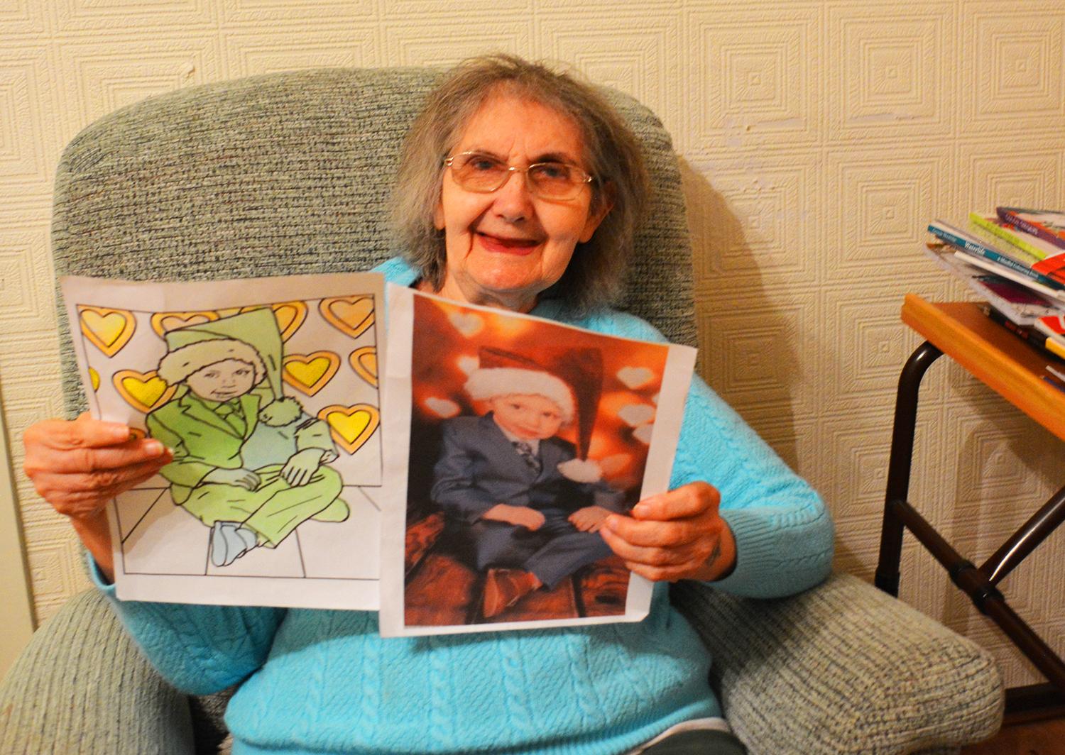 Woman holding up colouring art
