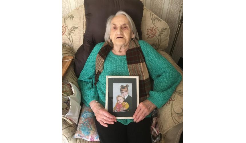 Dorothy holding a picture of her grandchildren