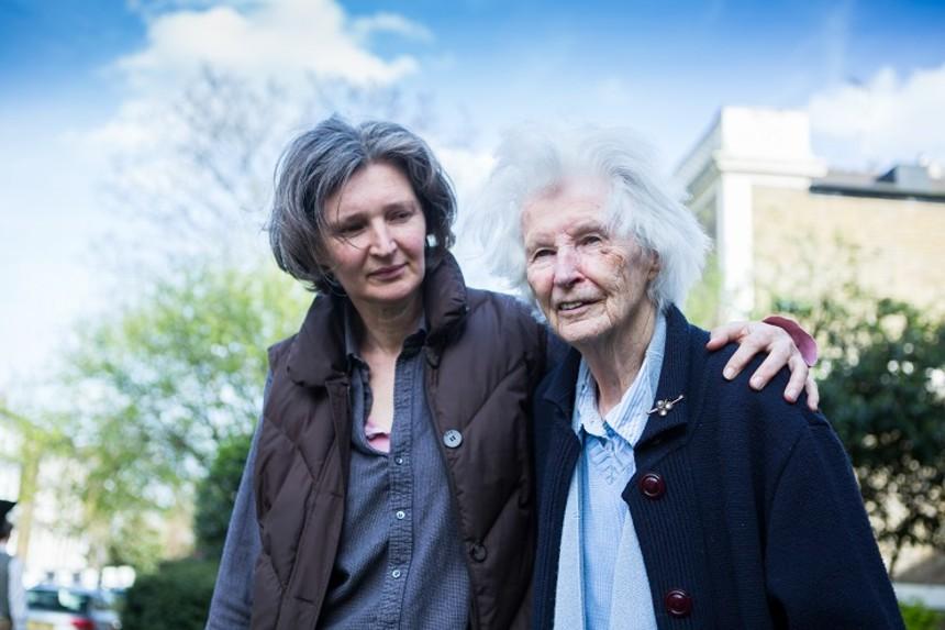 Carer walks with arm around person with dementia