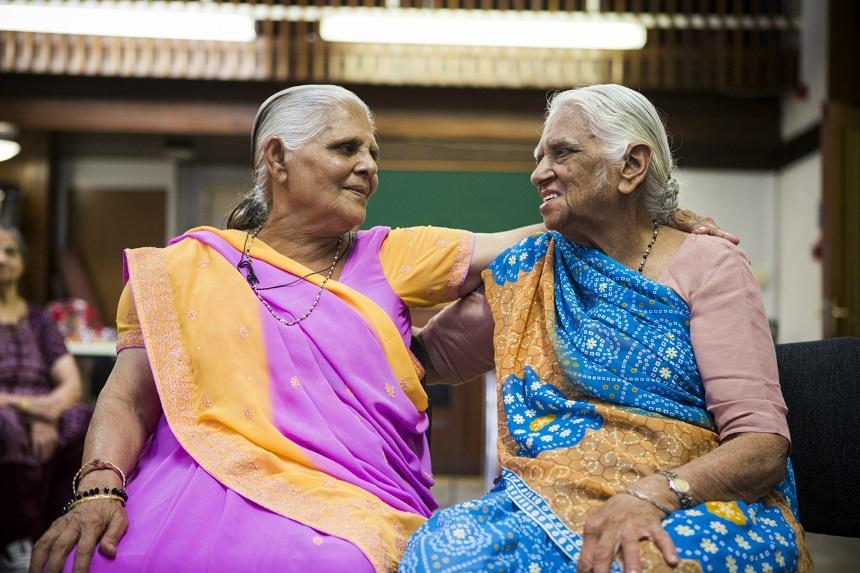 Two women wearing saris