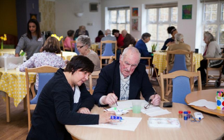 Two people doing a painting activity in a care home