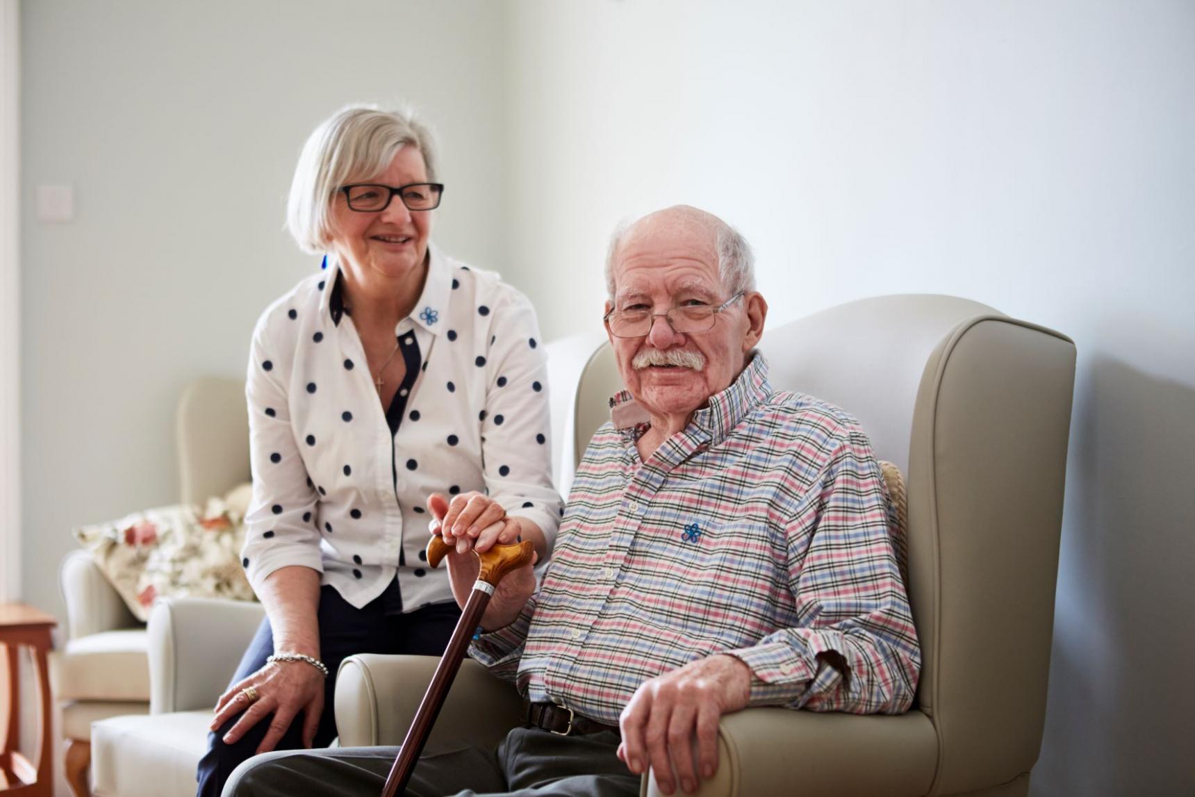 A man with dementia sitting with his carer.