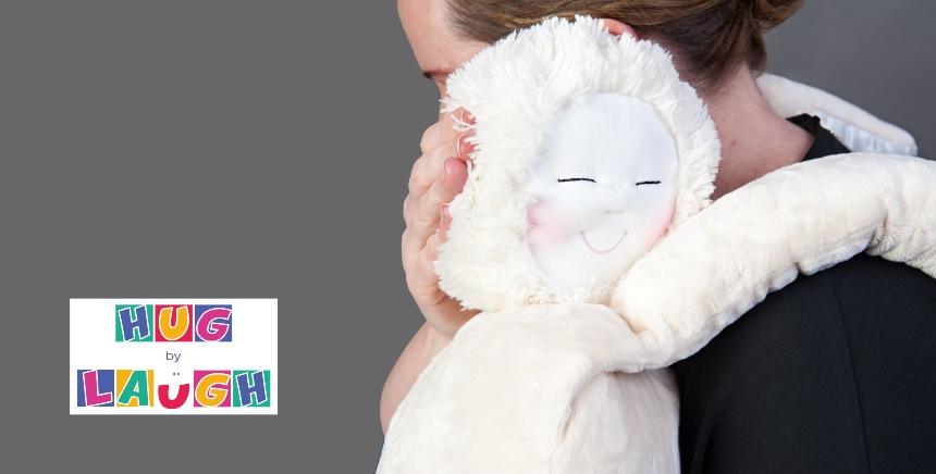 Close up of the HUG by Laugh toy cuddling a person