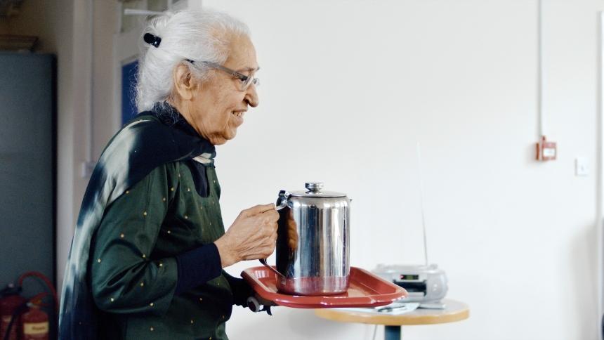 Bhagwant carrying a teapot to her community group in the centre