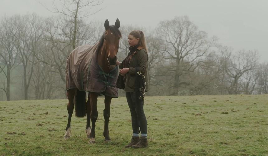 Saskia standing in a field with a horse