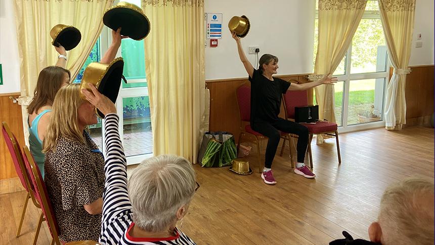 People holding hats in the air at a group activity