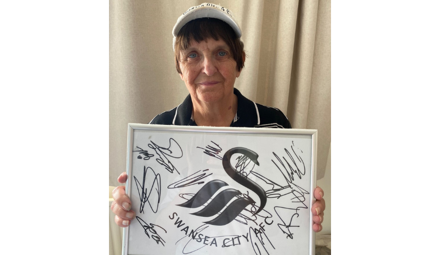 Sue holding up a signed Swansea City frame