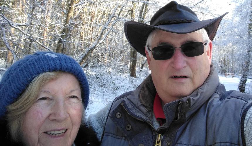 John and his partner wearing winter clothing outdoors in the snow