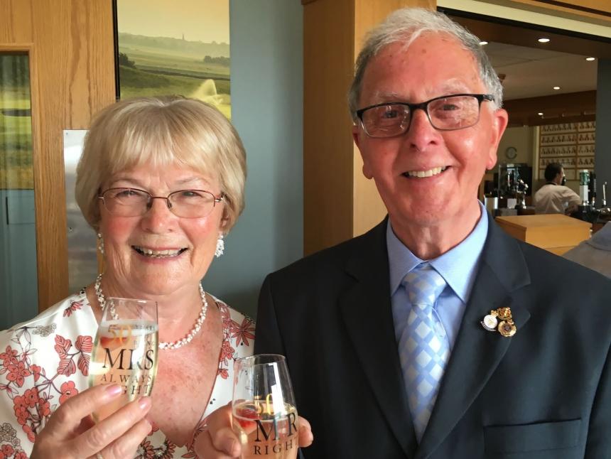 Bob and his wife, Vicky, holding glasses of prosecco at their 50th wedding anniversary party