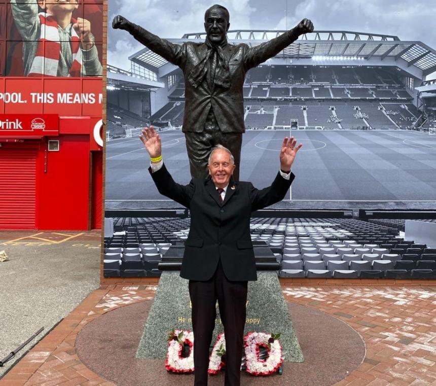 Bob stood with his arms in the air, in front of the Bill Shankly statue that is outside Anfield stadium