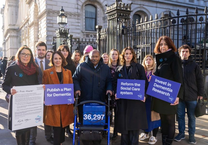 All-Party Parliamentary group on Dementia Chair Debbie Abrahams MP and Vice-Chair Elliot Colburn standing outside Downing Street with Dame Arlene Phillips, Vicky McClure, Ananga Moonesinghe, Alzheimer's Society CEO Kate Lee