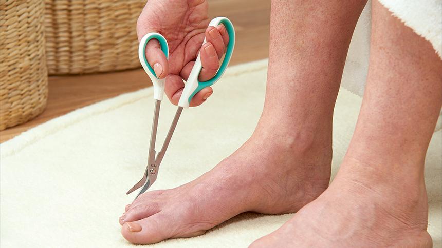 Someone is using a pair of Easi-grip toenail cutters to trim their toenails
